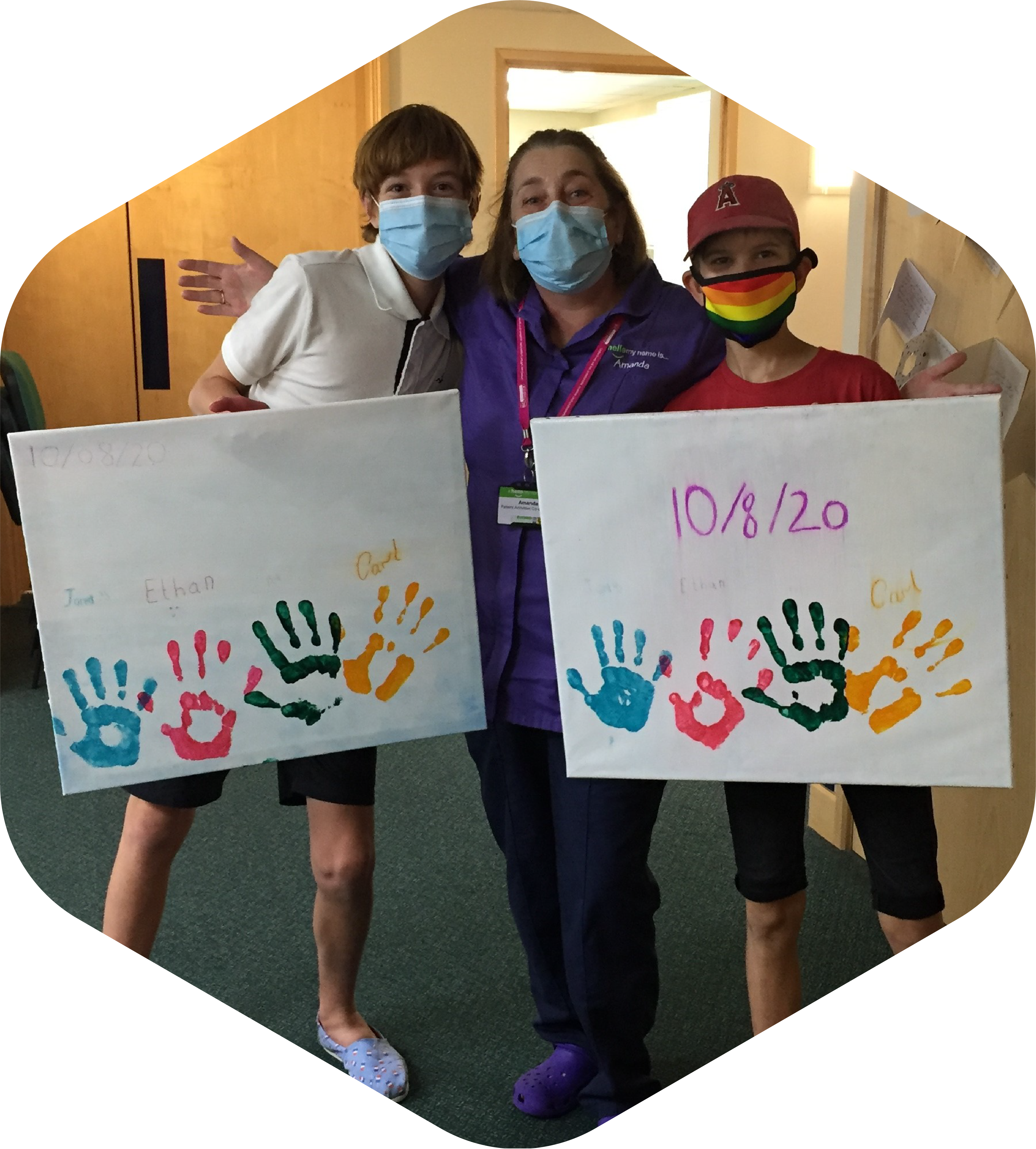 Picture of Ethan and Jared with Amanda, a nurse on the unit. Both boys are holding handprint memory canvases.